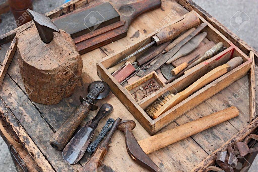 15756507-mesa-de-trabajo-con-herramientas-antiguas-del-zapatero-artesano-Foto-de-archivo.jpg