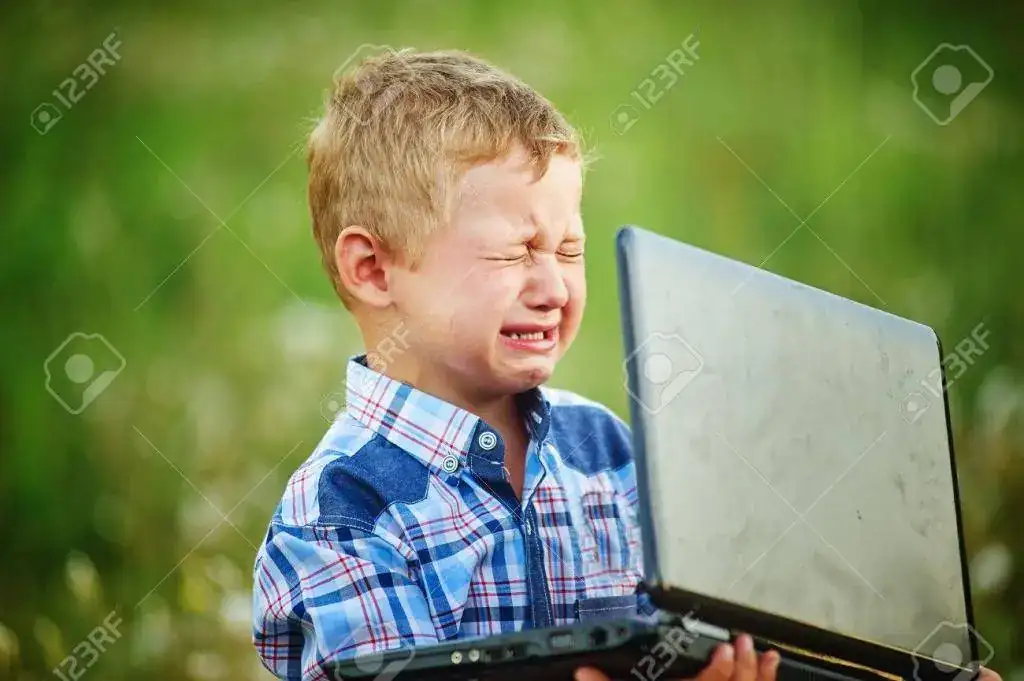 63048475-niño-llorando-amargamente-sosteniendo-el-ordenador-portátil.webp