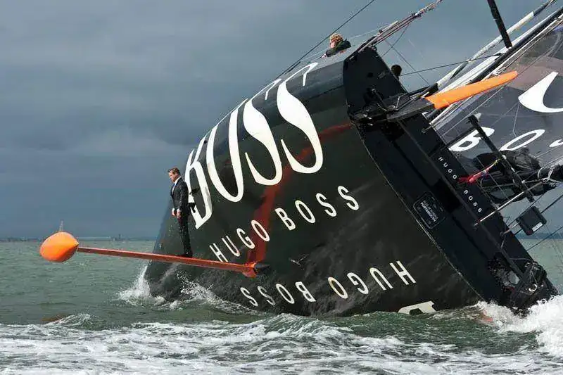 alk-hugo-boss-suit-boat-sailing-standing-on-rutter.webp