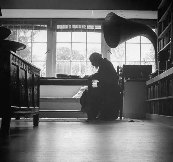 Artist Augustus John writing at his desk. 1946.webp