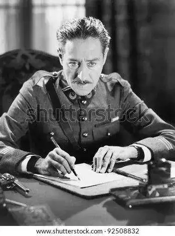 r-writing-a-letter-with-a-gun-next-to-him-92508832.webp