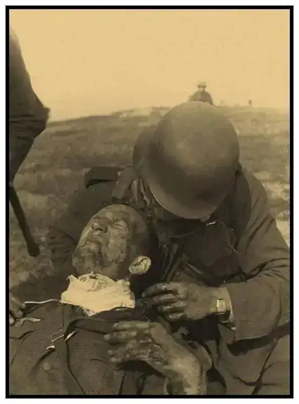 Un soldat allemand blesseÂ´ au cou est secouru par un camarade sur la front.webp